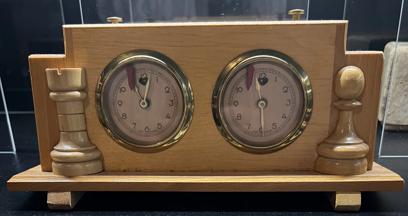 Jerger clock with decorative chess-piece supports.
